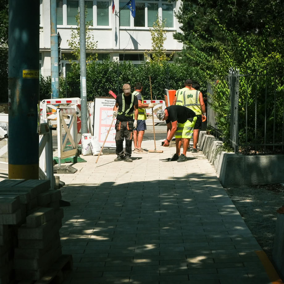 Une &eacute;quipe d'ouvriers du b&acirc;timent pose un trottoir &agrave; l'ext&eacute;rieur par une journ&eacute;e ensoleill&eacute;e &agrave; Bratislava.
